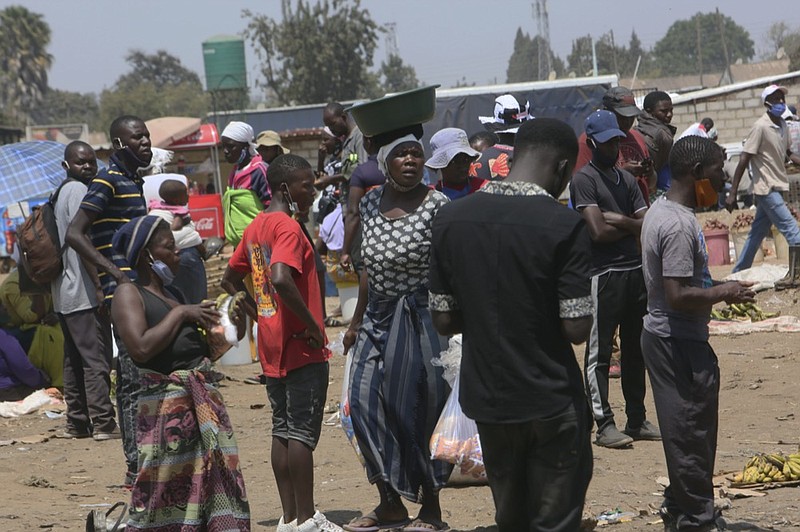 People are seen at a busy market in a poor township on the outskirts of the capital Harare, Monday, Nov, 15, 2021. (AP Photo/Tsvangirayi Mukwazhi)


