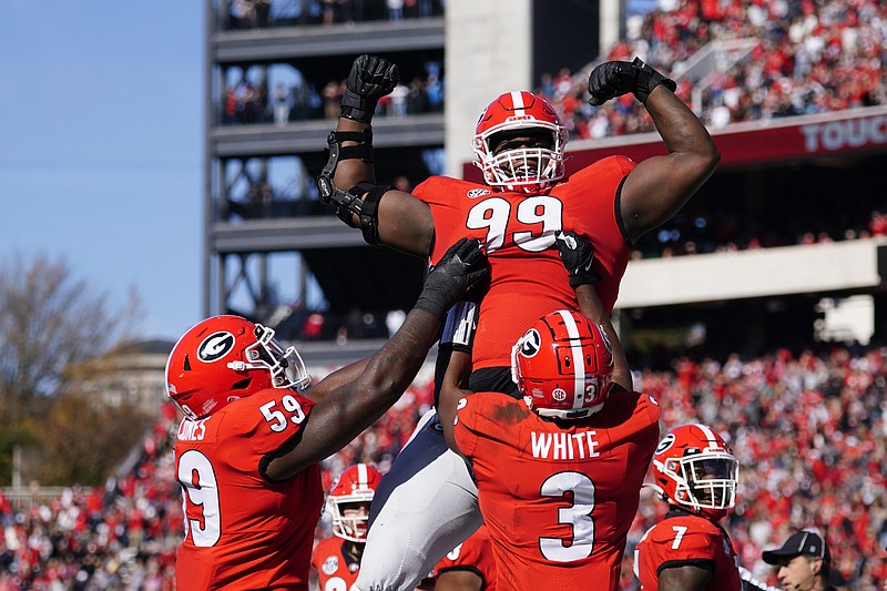 AP photo by John Bazemore / Georgia defensive lineman Jordan Davis is lifted into the air by running back Zamir White and offensive lineman Broderick Jones after scoring on a 1-yard touchdown run early in Saturday's home game against Charleston Southern.