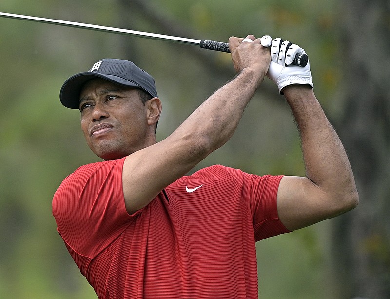 AP photo by Phelan M. Ebenhack / Tiger Woods watches his tee shot on the fourth hole during the final round of the PNC Championship on Dec. 20, 2020, in Orlando, Fla.