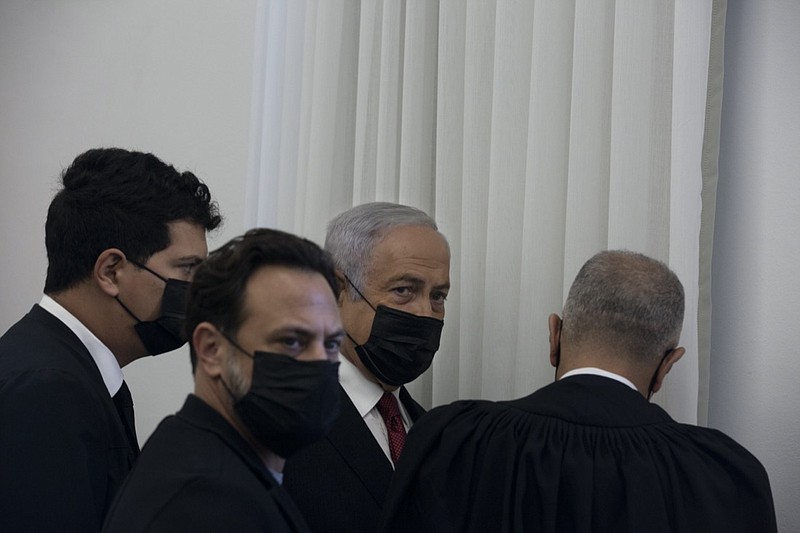 Former Israeli Prime Minister Benjamin Netanyahu, third from left, is flanked by lawyers before testimony by star witness Nir Hefetz, a former aide, in his corruption trial at the District Court in east Jerusalem, Monday, Nov. 22, 2021. (AP Photo/Maya Alleruzzo, Pool)

