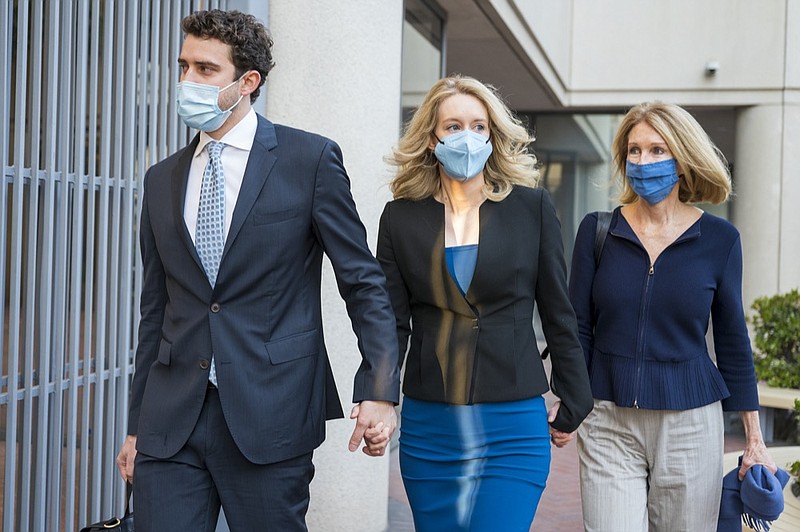 Elizabeth Holmes, center, walks into federal court in San Jose, Calif., Monday, Nov. 22, 2021. Holmes is accused of duping elite financial backers, customers and patients into believing that her startup was about to revolutionize medicine. (AP Photo/Nic Coury)


