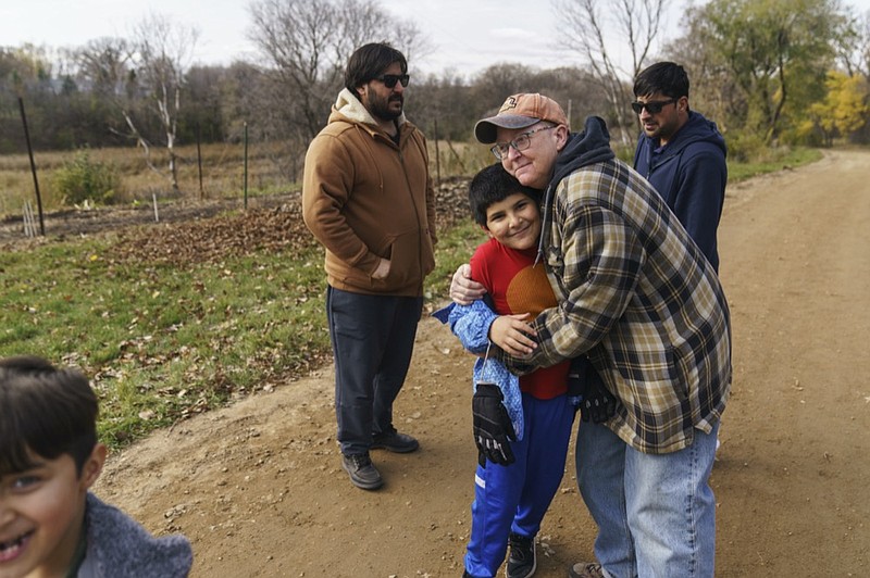 Caroline Clarin, right, hugs Haiwad Massoodi, 9, on a visit by his father, Sami, rear left, and Sami Massoodi's cousin Ihsanullah Patan, right, and Patan's son, Ali, 7, at her farm in Dalton, Minn., Saturday, Oct. 30, 2021. Clarin was consumed by anger over her program being gutted by the U.S. government. "I felt like I deserted them," she said about Massoodi, Patan and the other Afghans she worked with. Patan waited seven years for a special visa. When Clarin recently picked him up at the airport she was consumed with joy. "It was like my son came home," she said. (AP Photo/David Goldman)


