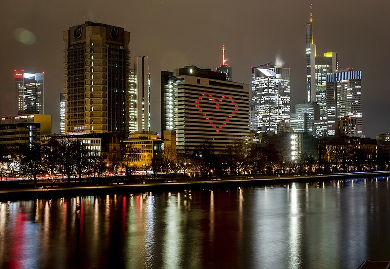 A hotel has switched on the lights in some rooms to form a heart near the buildings of the banking district in in Frankfurt, Germany, Dec. 10, 2020, as the German government discusses further restrictions to avoid the outspread of the coronavirus. Germany is set to mark 100,000 deaths from COVID-19 this week, passing a somber milestone that several of its neighbors crossed months ago but which some in Western Europe's most populous nation had hoped to avoid. (AP Photo/Michael Probst, File)