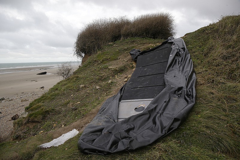A damaged inflatable small boat is pictured on the shore in Wimereux, northern France, Thursday, Nov. 25, 2021 in Calais, northern France. Children and pregnant women were among at least 27 migrants who died when their small boat sank in an attempted crossing of the English Channel, a French government official said Thursday. French Interior Minister Gerald Darmanin also announced the arrest of a fifth suspected smuggler thought to have been involved in what was the deadliest migration tragedy to date on the dangerous sea lane.(AP Photo/Michel Spingler)