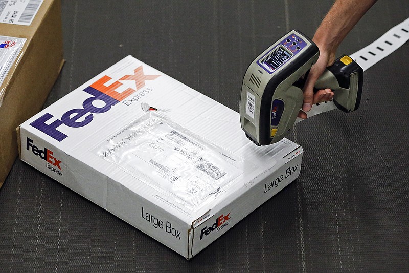 In this July 9, 2014 photo, a worker scans packages at the FedEx Express station in Nashville, Tenn. (AP Photo/Mark Humphrey)