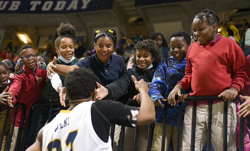 Staff photo by Matt Hamilton / Hamilton County elementary school students visit with UTC's Josh Ayeni before the start of the second half of Tuesday's game against Covenant College at McKenzie Arena. Ayeni scored 14 points to help the Mocs roll to a 100-39 win.