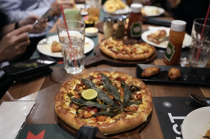 A pizza topped with a cannabis leaf is served to the customers at a restaurant in Bangkok, Thailand on Nov. 24, 2021. The Pizza Company, a Thai major fast food chain, has been promoting its "Crazy Happy Pizza", an under-the-radar product topped with a cannabis leaf. It's legal but won't get you high. (AP Photo/Sakchai Lalit)


