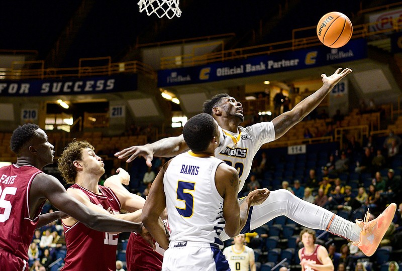 Staff photo by Robin Rudd / UTC's Silvio De Sousa reaches to pull in an offensive rebound during the Mocs' nonconference game against College of Charleston on Saturday at McKenzie Arena. The Cougars won 68-66.