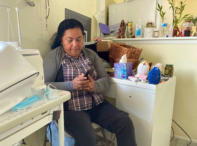 Rosalidia Dardon, 54, looks at a picture of her daughter in El Salvador as she sits in a refugee house in Texas, awaiting asylum or a protected immigration status on Nov. 4, 2021. (Acacia Coronado/Report for America via AP)


