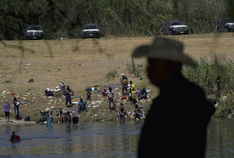 FILE - Migrants, many from Haiti, wade across the Rio Grande from Del Rio, Texas, to return to Ciudad Acuna, some to avoid possible deportation from the United States and others to get supplies, on Sept. 22, 2021. (AP Photo/Fernando Llano, File)


