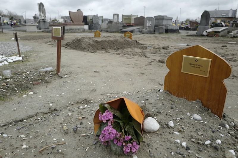 FILE- A bouquet of flower lays on the tomb of Yasser Abdallah, from Sudan, who died in an attempt to cross the English Channel in a truck on Sept. 28, 2021, in the Nord Cemetery of Calais, northern France, Thursday, Nov. 25, 2021. (AP Photo/Rafael Yaghobzadeh, File)


