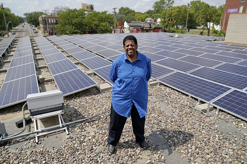 Bishop Richard Howell poses Aug. 19, 2021 beside some of the 630 solar panels on the roof of Shiloh Temple International Ministries in Minneapolis The church is one of many "community solar" providers popping up around the U.S. as surging demand for renewable energy inspires new approaches. Aug. 19, 2021, in Minneapolis. (AP Photo/Jim Mone)

