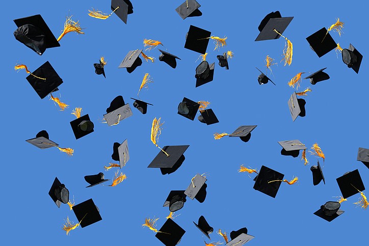 Getty Images / Graduation caps are thrown into the air.