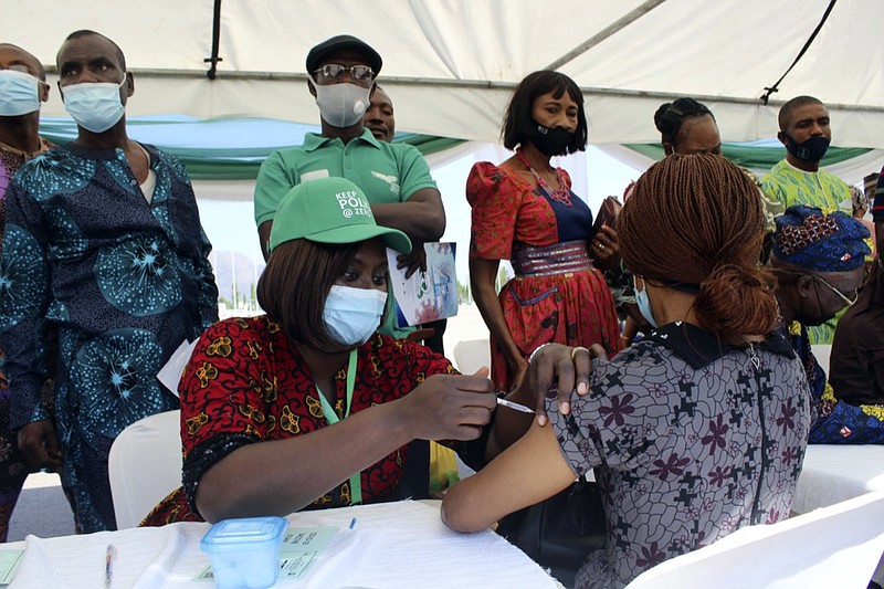 FILE - A woman receives an AstraZeneca coronavirus vaccine in Abuja, Nigeria, on Nov 19, 2021. The emergence of the new omicron variant and the world's desperate and likely futile attempts to keep it at bay are reminders of what scientists have warned for months: The coronavirus will thrive as long as vast parts of the world lack vaccines. (AP Photo/Gbemiga Olamikan, File)