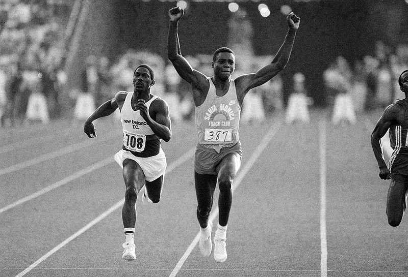 FILE - U.S. athlete Carl Lewis raises his arms in victory as he wins the 100-meter final ahead of third-place Emmit King, left, at the U.S. Olympic track and field trials at the Coliseum in Los Angeles, June 18, 1984. A former University of Alabama track star and Olympian was killed in a shootout with another man, authorities say. The Jefferson County Coroner's Office on Monday, Nov. 29, 2021, identified Emmit King and Willie Albert Wells as the two men who died after exchanging gunfire in Bessemer on Sunday, AL.com reported. King, 62, was a sprinter and a member of the U.S. relay team for the Summer Olympics in 1984 and 1988, but he didn't compete. (AP Photo/Lennox McLendon, File)