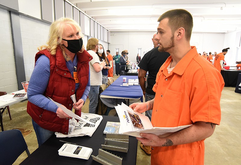 Staff Photo by Matt Hamilton / Inmate William Henderson, right, talks with Carrin Smith at the Valmont Industries booth at the Silverdale Detention Center on Tuesday, Nov. 30, 2021. Several businesses were seeking potential employees at a job fair for prisoners who will be released soon.