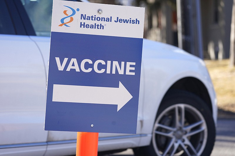 A sign directs motorist to a vaccination site at National Jewish Hospital on March 6, 2021, in east Denver. Merriam-Webster has declared vaccine its 2021 word of the year. (AP Photo/David Zalubowski, File)
