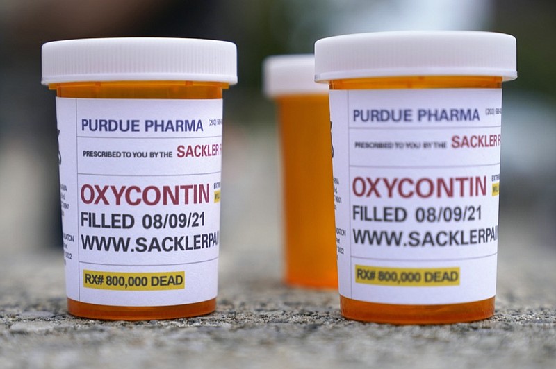 FILE - In this Aug. 9, 2021, file photo, fake pill bottles with messages about OxyContin maker Purdue Pharma are displayed during a protest outside the courthouse where the bankruptcy of the company is taking place in White Plains, N.Y. (AP Photo/Seth Wenig, File)


