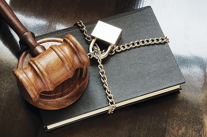 Book with wooden judge gavel, chain and padlock on wooden table, censorship concept. / Getty Images/iStock/Valerii Evlakhov