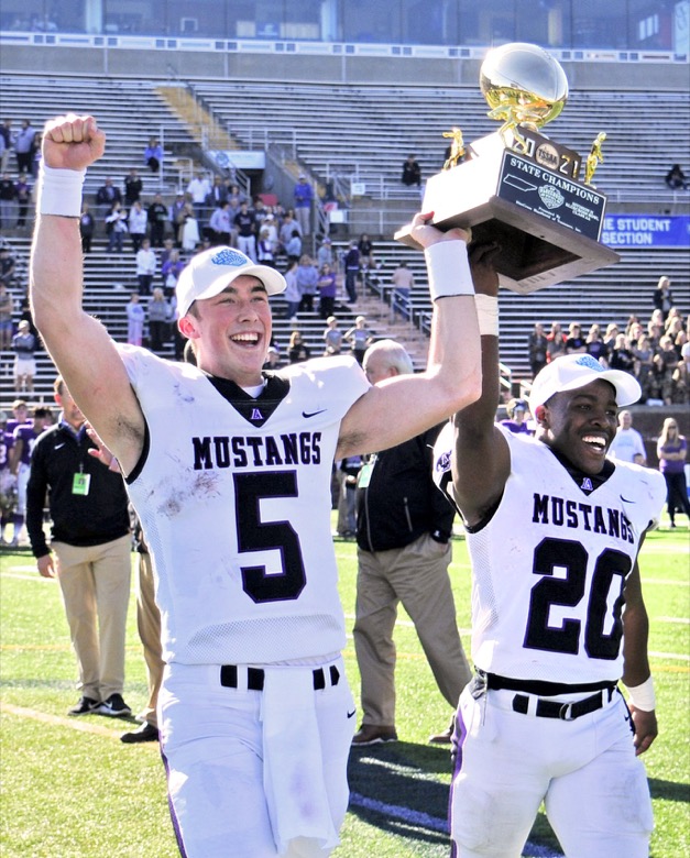Staff Photo by Robin Rudd / Lipscomb's Luther Richesson (5) and Alexander Broome (20) carry the championship trophy off the field. The Lipscomb Academy Mustangs defeated the Christ Presbyterian Academy Lions 27 to 0 to win the TSSAA Division II Class AA state football championship in the BlueCross Bowl held at Finley Stadium.