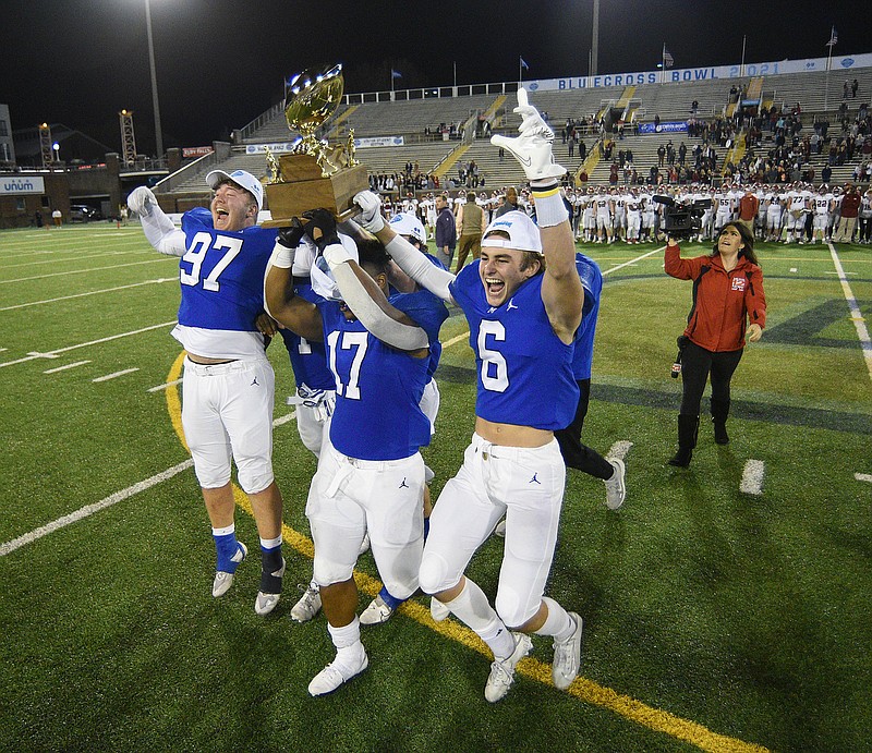 Staff photo by Matt Hamilton / McCallie football players Thomas Pilon (97), Aaron Crowder (17) and Austin Breedlove (6) carry the gold ball trophy to their waiting teammates Thursday night at Finley Stadium. McCallie beat Nashville's Montgomery Bell Academy 28-7 to win the TSSAA Division II-AAA BlueCross Bowl, completing an undefeated season and wrapping up the program's third straight state championship.