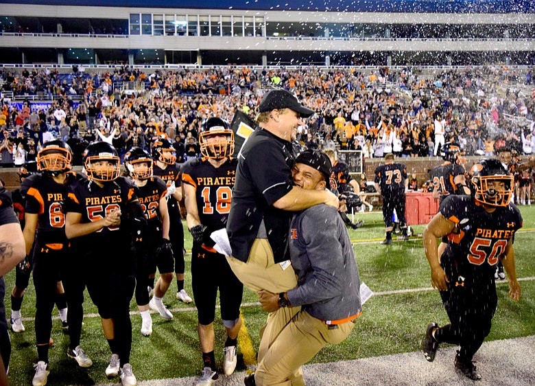 Staff photo by Robin Rudd / South Pittsburg assistant coach Terrell Robinson lifts co-head coach Wes Stone as time expires in the TSSAA Class 1A BlueCross Bowl on Friday at Finley Stadium. Stone and co-head coach Heath Grider helped the Pirates finish off an improbable run to the program's sixth state championship with a 24-21 win against previously unbeaten McKenzie.