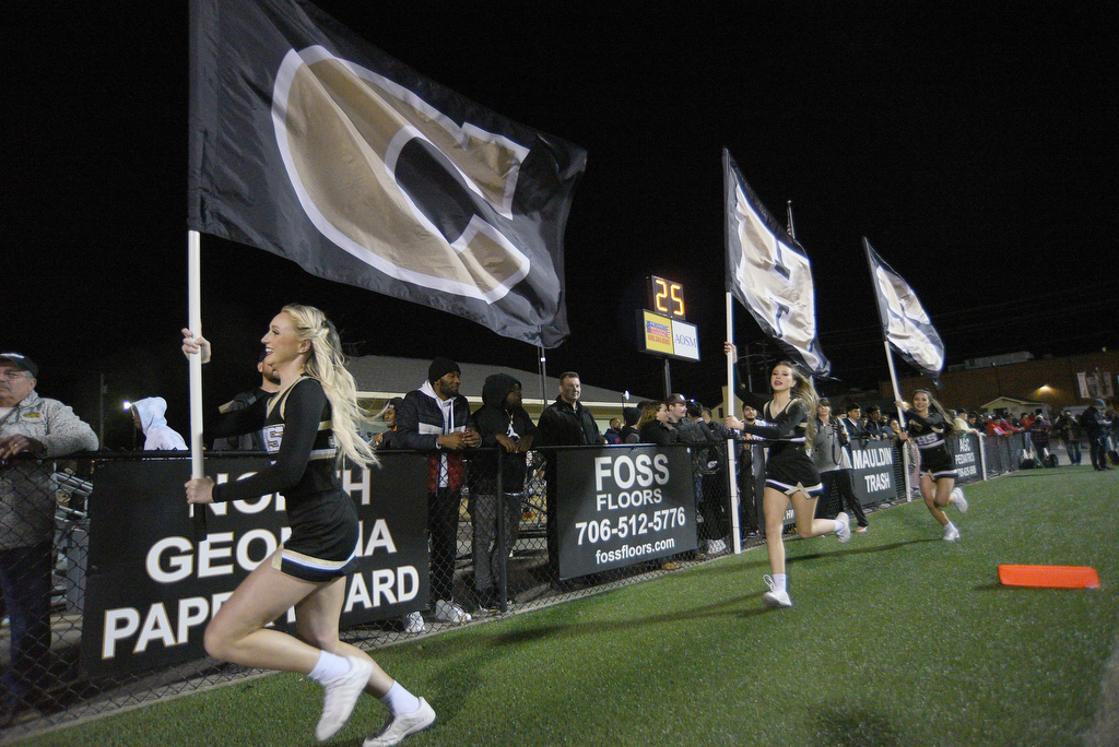 Staff Photo by Matt Hamilton / Calhoun High cheerleaders carry CHS flags in the end zone after a score on Friday, December 3, 2021 in Calhoun, Ga. Calhoun High hosted Blessed Trinity in a GHSA Class 5A football semifinal game Friday.