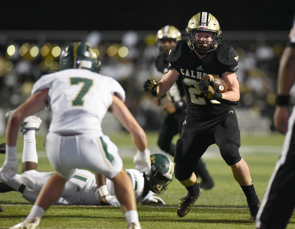 Staff Photo by Matt Hamilton / Calhoun High (21) Caden Williams carries the ball as Blessed Trinity (7) Ryan Combs defends on Friday, December 3, 2021 in Calhoun, Ga. Calhoun High hosted Blessed Trinity in a GHSA Class 5A football semifinal game Friday.