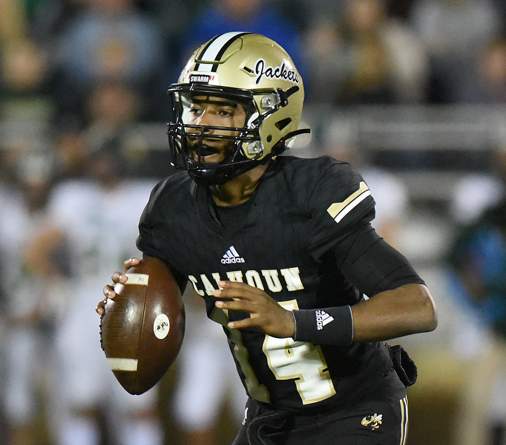 Staff Photo by Matt Hamilton / Calhoun High (14) Christian Lewis scrambles as he looks for an open receiver on Friday, December 3, 2021 in Calhoun, Ga. Calhoun High hosted Blessed Trinity in a GHSA Class 5A football semifinal game Friday.