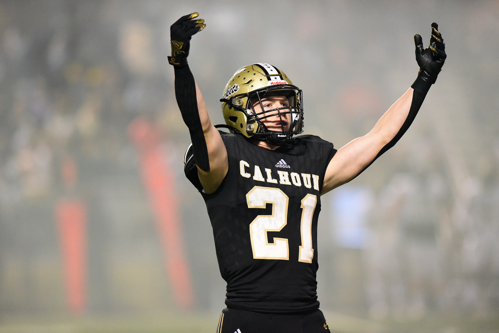 Staff Photo by Matt Hamilton / Calhoun High (21) Caden Williams signals for the fans to cheer as the smoke from the team taking the field dissipates before the kickoff on Friday, December 3, 2021 in Calhoun, Ga. Calhoun High hosted Blessed Trinity in a GHSA Class 5A football semifinal game Friday.