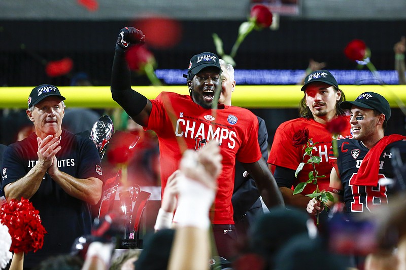 AP photo by Chase Stevens / Utah linebacker Devin Lloyd, center, celebrates alongside coach Kyle Whittingham, left, quarterback Cameron Rising, second from right, and wide receiver Britain Covey after the Utes defeated Oregon 38-10 to win the Pac-12 championship game Friday night in Las Vegas.