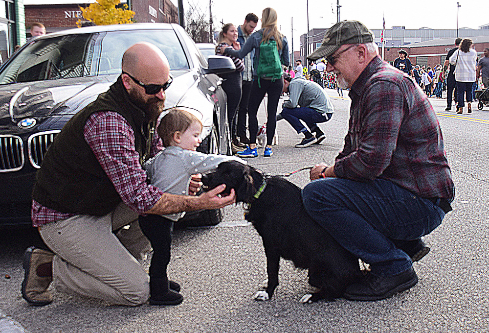 Staff Photo by Robin Rudd / From left, Cole Murphy holds Rilly Brook Murphy as she pets Thomas Offutt's dog, Nera. The 15th annual MAINx24 EPB Southside Parade and street festival took place on December 4, 2021.