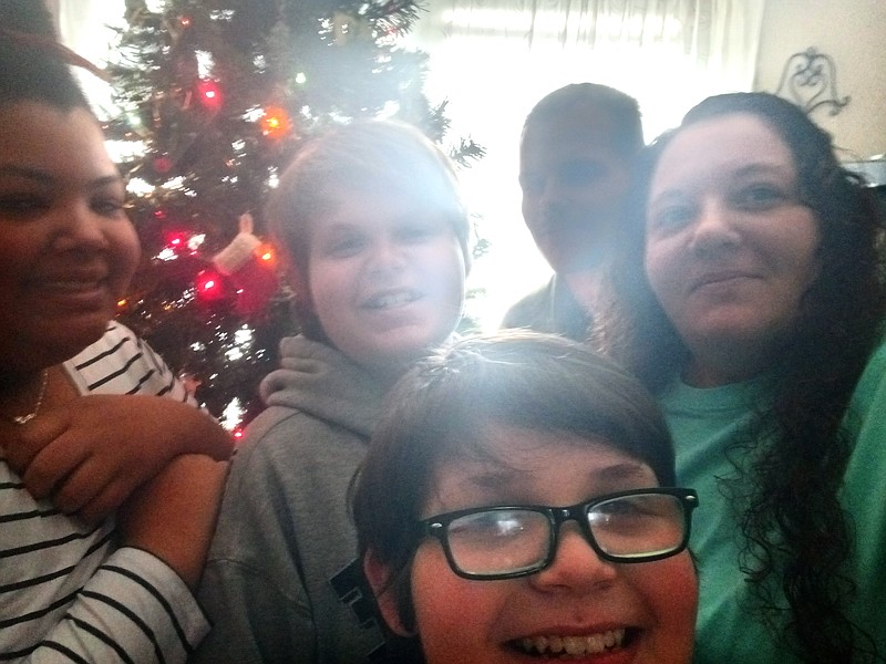 Kristi Orick, far right, shoots a selfie with her family and loved ones in front of a Christmas tree on Saturday. They are, from left, Summer Orick, 14, Andrew Hudson, 11, Cayden Hudson, 10, and Scottie Bryant. / Courtesy photo by Kristi Orick