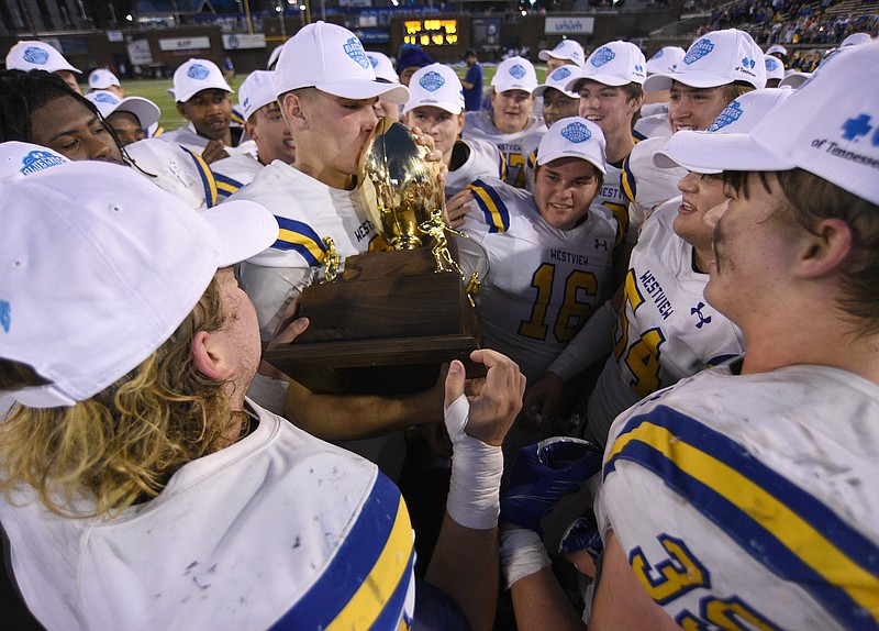 Staff photo by Matt Hamilton / Westview quarterback Ty Simpson kisses the state championship trophy after helping lead his team to a 55-14 win against Hampton in the TSSAA Class 2A BlueCross Bowl on Saturday at Finley Stadium.