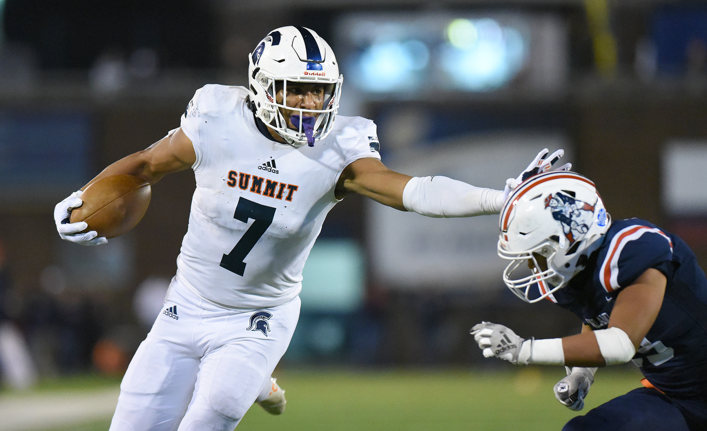 Staff Photo by Matt Hamilton / Summit High School (7) Keaton Wade stiff arms an Oakland defender on his way to the end zone on Saturday, December 4, 2021 at Finley Stadium during the Class 6A championship game.
