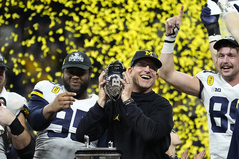 AP photo by AJ Mast / Michigan football coach Jim Harbaugh celebrates with his team after the Wolverines beat Iowa 42-3 on Saturday night to win the Big Ten championship game in Indianapolis.