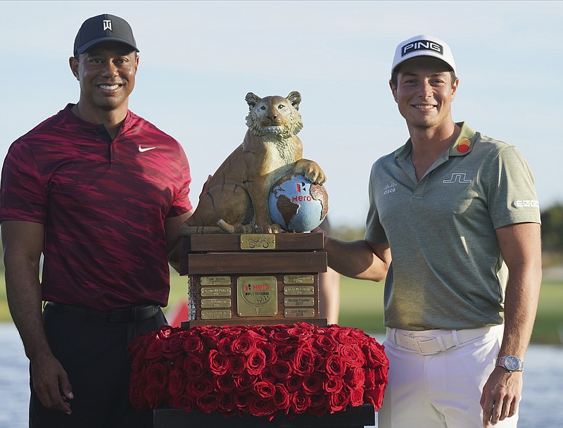 AP photo by Fernando Llano / Winning golfer Viktor Hovland, right, and tournament host Tiger Woods pose with the championship trophy after the final round of the Hero World Challenge on Sunday at Albany Golf Club, in New Providence, Bahamas. Hovland won the PGA Tour event by a stroke for his third victory of the year.