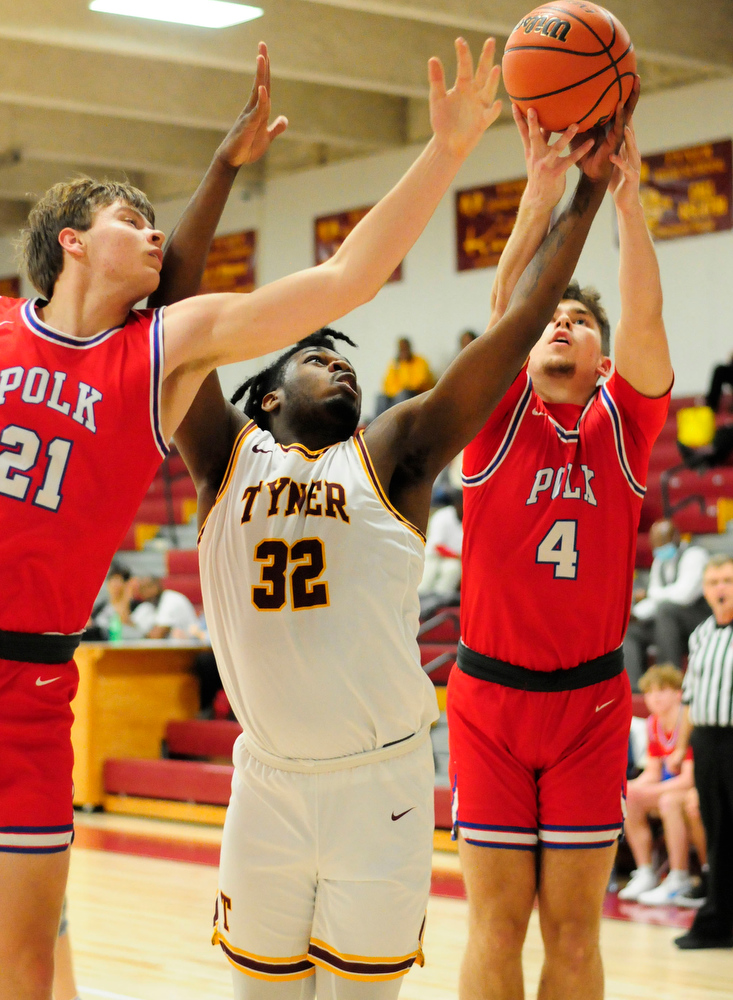 Staff Photo by Robin Rudd / Polk's Alex Armstrong (21) and Noah Shaw (4) battle for a rebound with Tyner's Anthony Sims (32). The Polk County Wildcats visited the Tyner Rams in TSSAA boy's basketball on December 7, 2021.