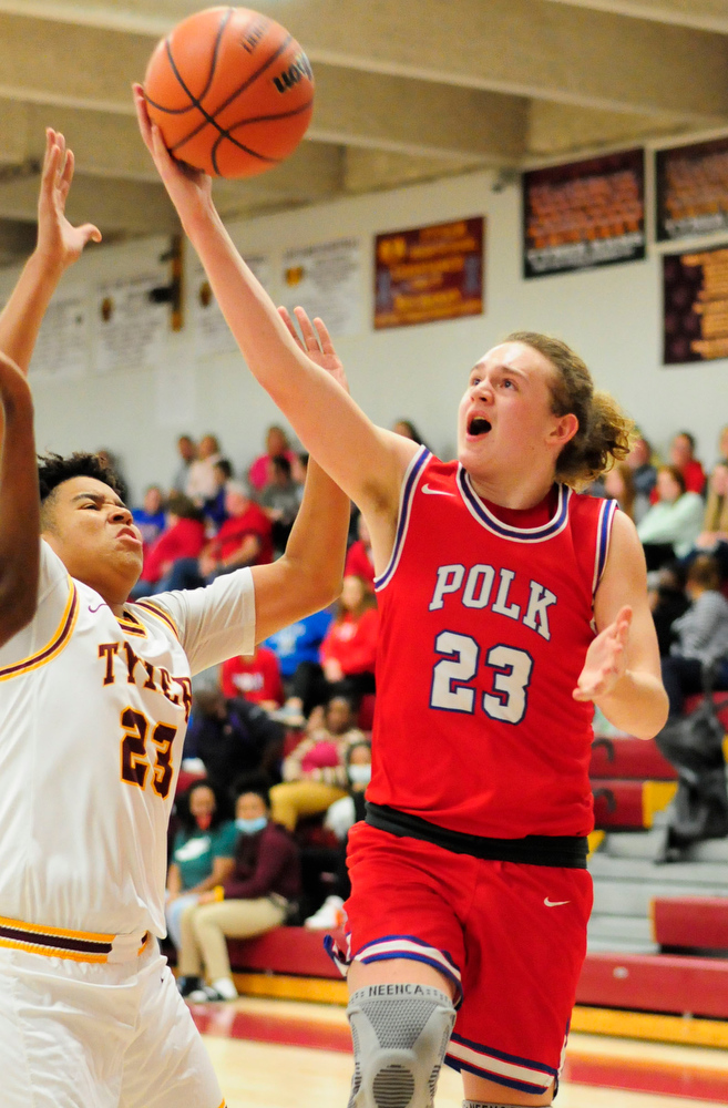 Staff Photo by Robin Rudd / Polk's Tucker Patterson (23) drives in for the layup, as Tyner's Joshua Jackson (23) defends. The Polk County Wildcats visited the Tyner Rams in TSSAA boy's basketball on December 7, 2021.