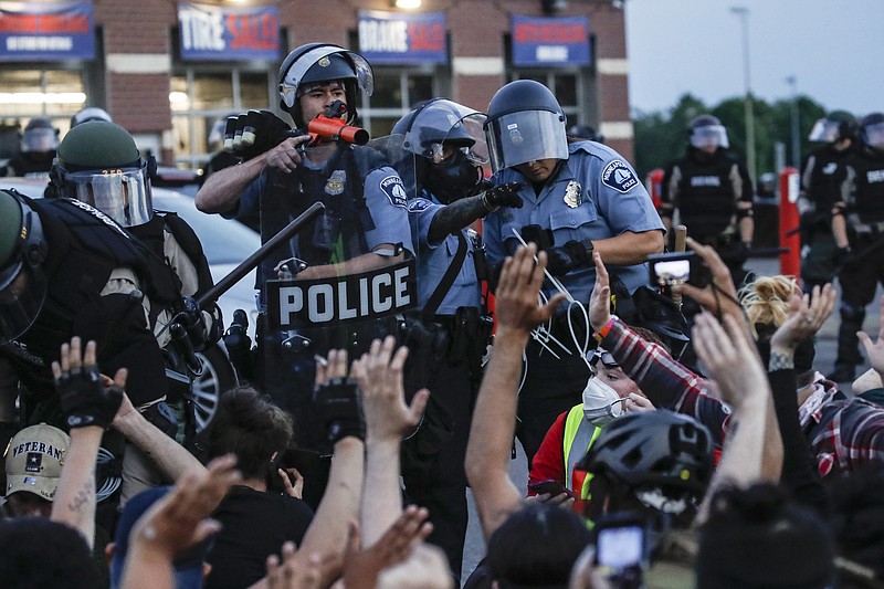 AP File Photo/John Minchillo / Police and protesters tangle on South Washington Street in Minneapolis following the death of George Floyd in May 2020.