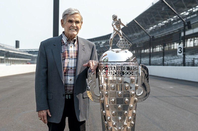 AP photo by Doug McSchooler / Former driver Al Unser Sr., a four-time winner of the Indianapolis 500, poses with the Borg-Warner Trophy at Indianapolis Motor Speedway in July.