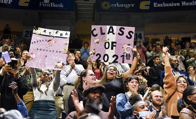Mom Shia Robertson, left, and sister Kennedy Gray, right, hold signs for graduate Catera Sawyers during first of two graduation ceremonies for undergraduate students on Saturday, Dec. 11, 2021 in McKenzie Arena. / Photo by Angela Foster