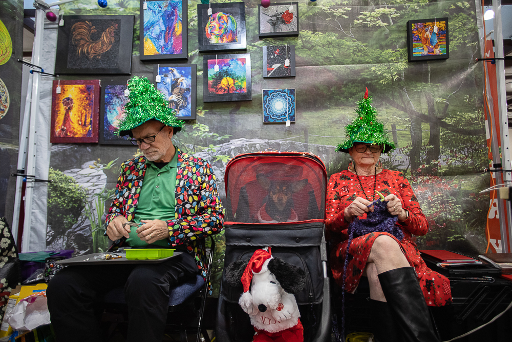 Staff photo by Troy Stolt / Pete and Kei Petersen of Kei's Crafty Tearalins work on new pieces at their booth as their dog Bella sits in a stroller between them during the Holiday Market at the Chattanooga Convention Center on Saturday, Dec. 11, 2021.