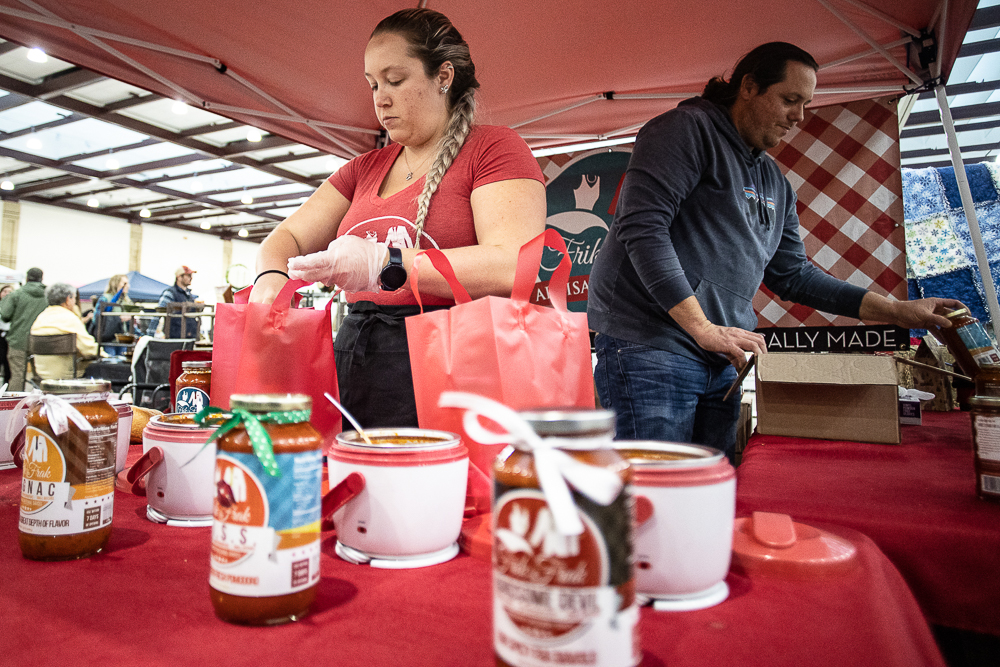 Staff photo by Troy Stolt / Frik and Frak Artisan Sauces employees Mary and Michael Perry help customers with orders during the Holiday Market at the Chattanooga Convention Center on Saturday, Dec. 11, 2021.