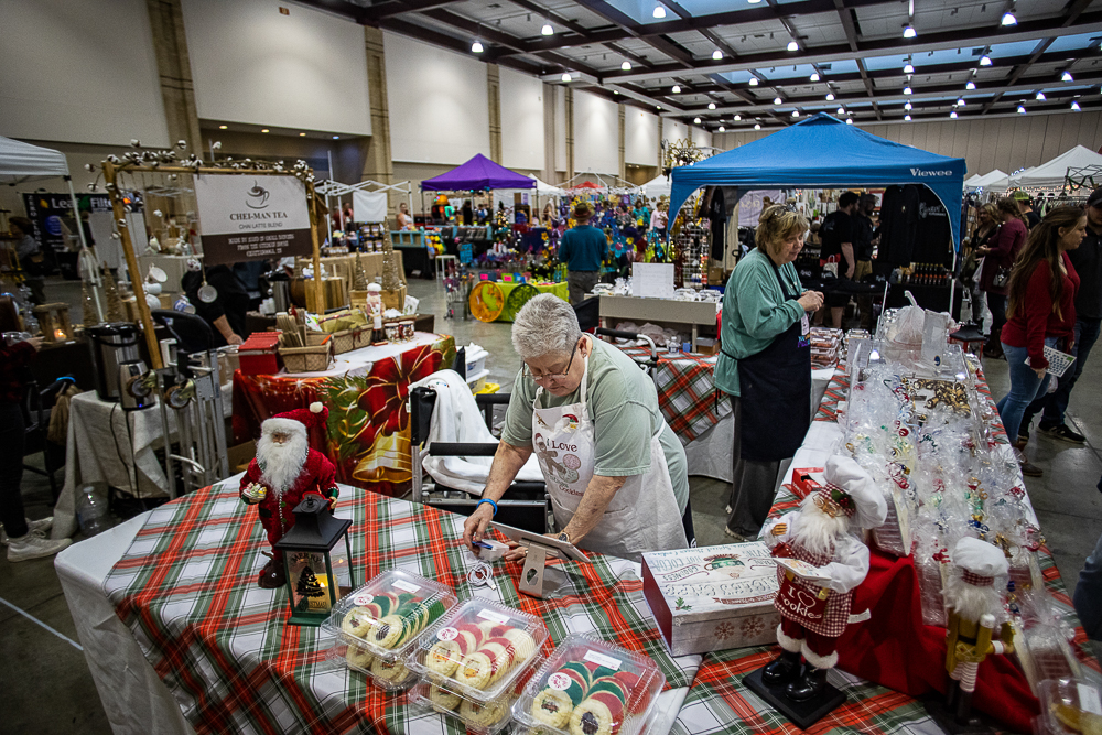 Staff photo by Troy Stolt / Candy Meck of Simply Southern Bakery rings up a customer's order during the Holiday Market at the Chattanooga Convention Center on Saturday, Dec. 11, 2021.