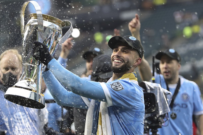 AP photo by Amanda Loma / New York City FC forward Valentin Castellanos celebrates with the league championship trophy after his team beat the host Portland Timbers via penalty kick shootout in the MLS Cup on Saturday.