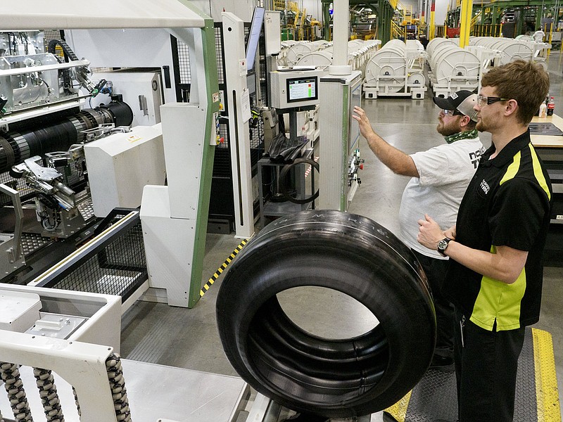 Staff file photo / Michael Leonard, left, and Brett Spurgeon work with a tire at Nokian Tyres' production plant in Dayton, Tennessee earlier this year.