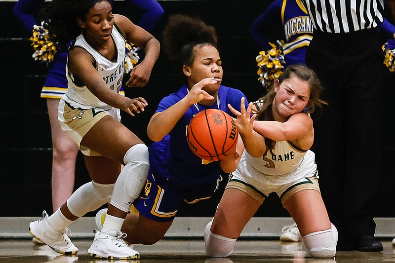 Staff photo by Troy Stolt / Notre Dame's Maliyah Maples (12), left, and Kenzie Campbell (3), right, battle for a loose ball with Boyd Buchannan's Jahsa Sanders (11) during the girls basketball game between Boyd Buchanan and Notre Dame on Tuesday, Dec. 14, 2021 at Notre Dame High School in Chattanooga, Tenn.