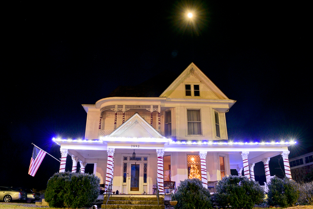Staff Photo by Robin Rudd / The Moon hovers Tuesday over a Victorian Home whose columns are decorated as candy canes. Pushed through by the vision of resident and business owner Lola Sells and the help of many others, downtown Pikeville, Tennessee, has been transformed this year with the goal of having Christmas decorations (preferably lights) on every home and business on the main street through downtown. Sells says her goal is to make it look like a Hallmark town that people would want to come visit and spend money in.