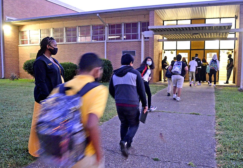 Staff Photo by Robin Rudd / Principal Tiffany Earvin, left, greets students arriving by bus at Orchard Knob Middle School in August.